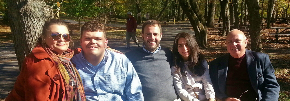 group of adults sitting on park bench