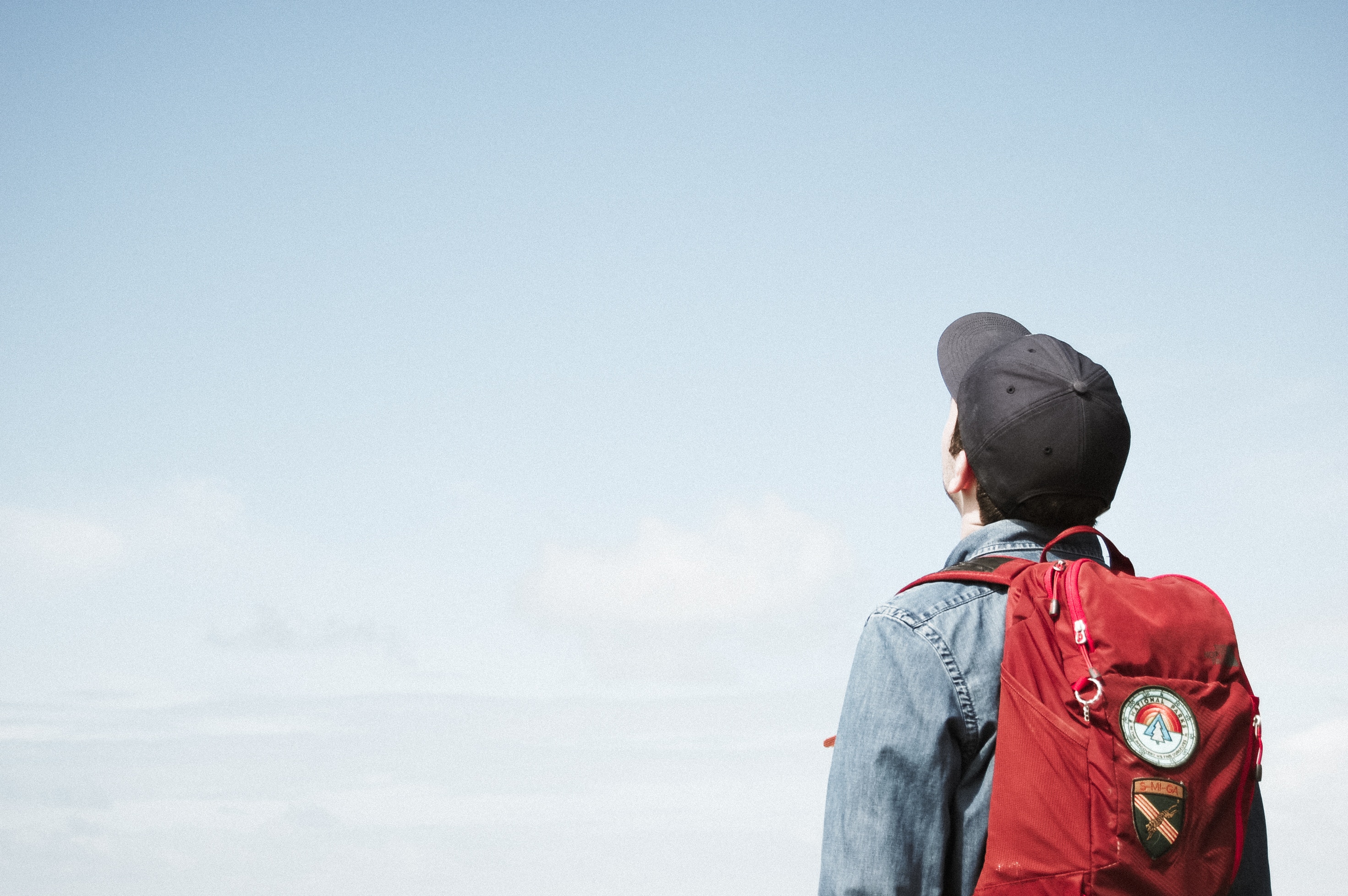 boy with backpack looking at sky