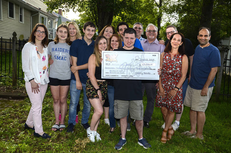 The Banks family and friends holding a check for $17,073.32.holding a check for Autism New Jersey.